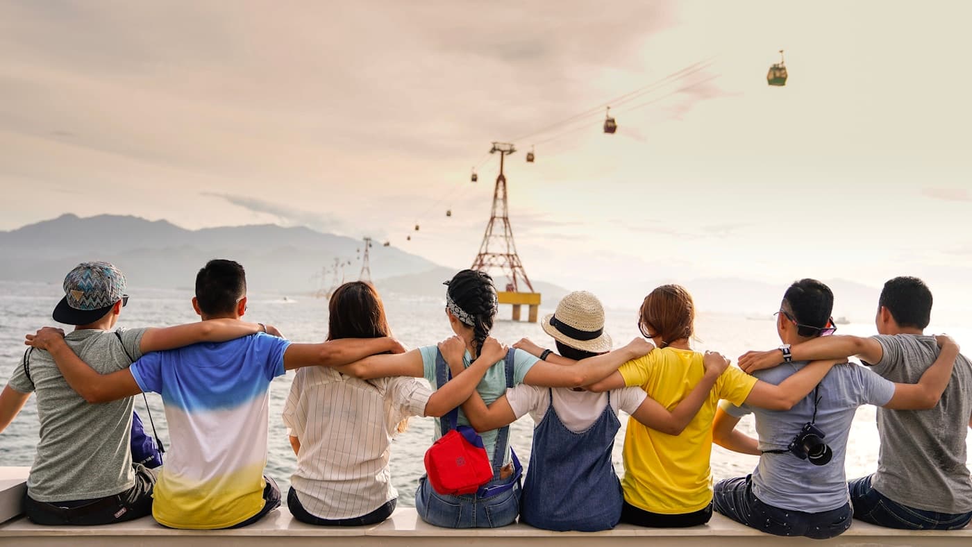 Diverse group of friends raising glasses together at an outdoor party